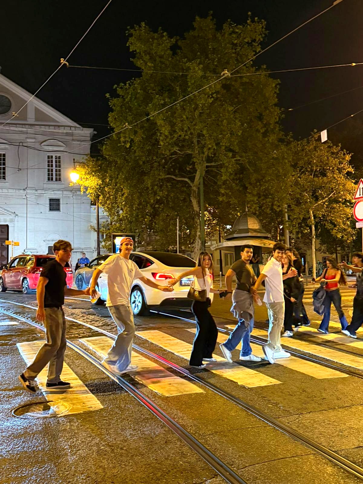 A Realo crew crossing the street together mid-sidequest at night in Lisbon